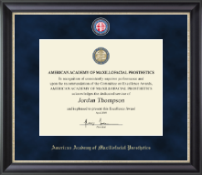 Professional certificate frame with black wood molding and navy suede matting, displaying an American Academy of Maxillofacial Prosthetics excellence award. The matting features the academy's emblem at the top and the full organization name at the bottom.