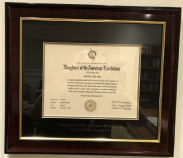 Custom dark wood frame with gold inner trim, featuring a Daughters of the American Revolution certificate. The black matting below the certificate is inscribed with ‘Daughters of the American Revolution — God ★ Home ★ Country’ in gold lettering.