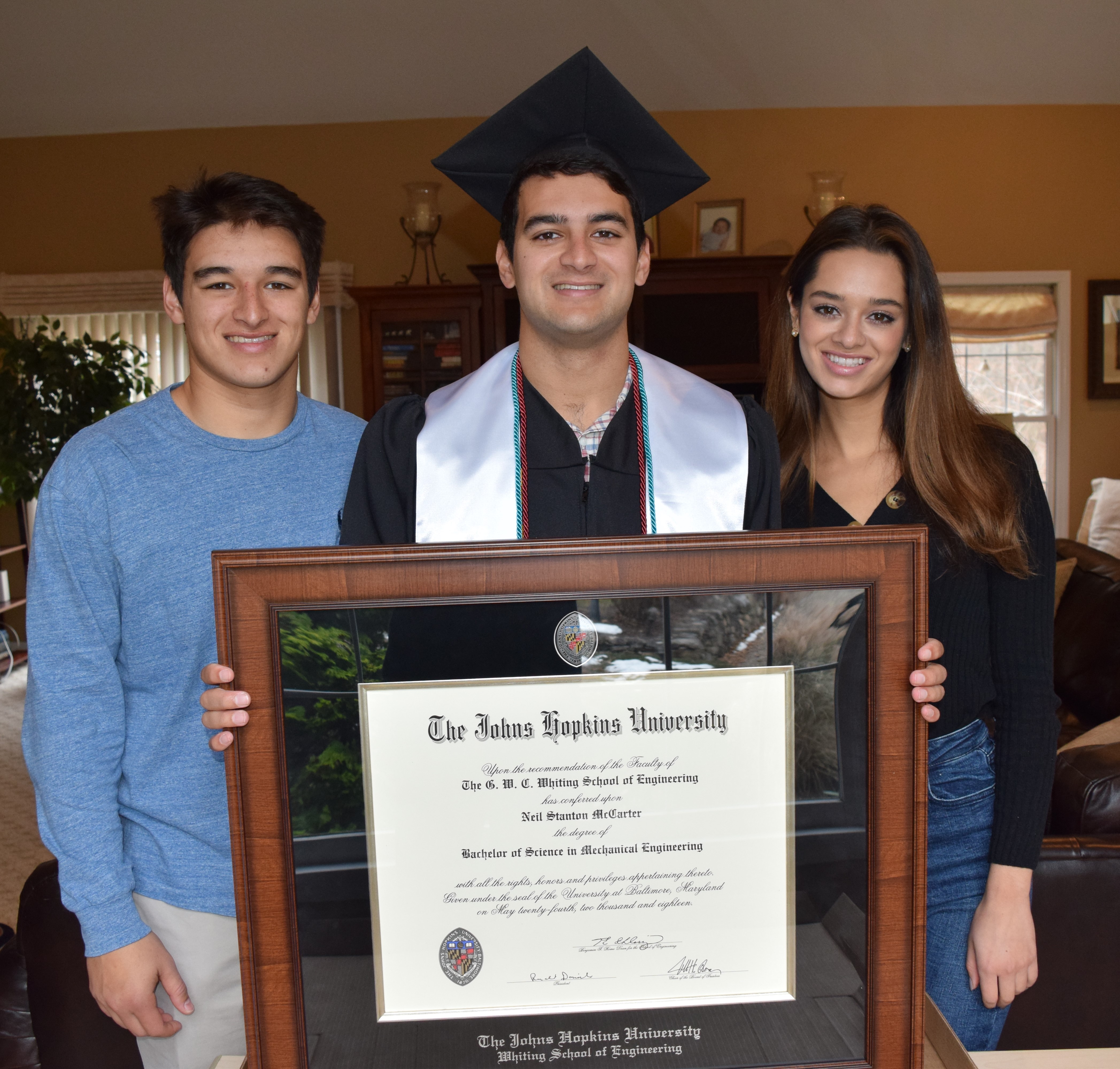 Graduate holding his diploma in his diploma frame