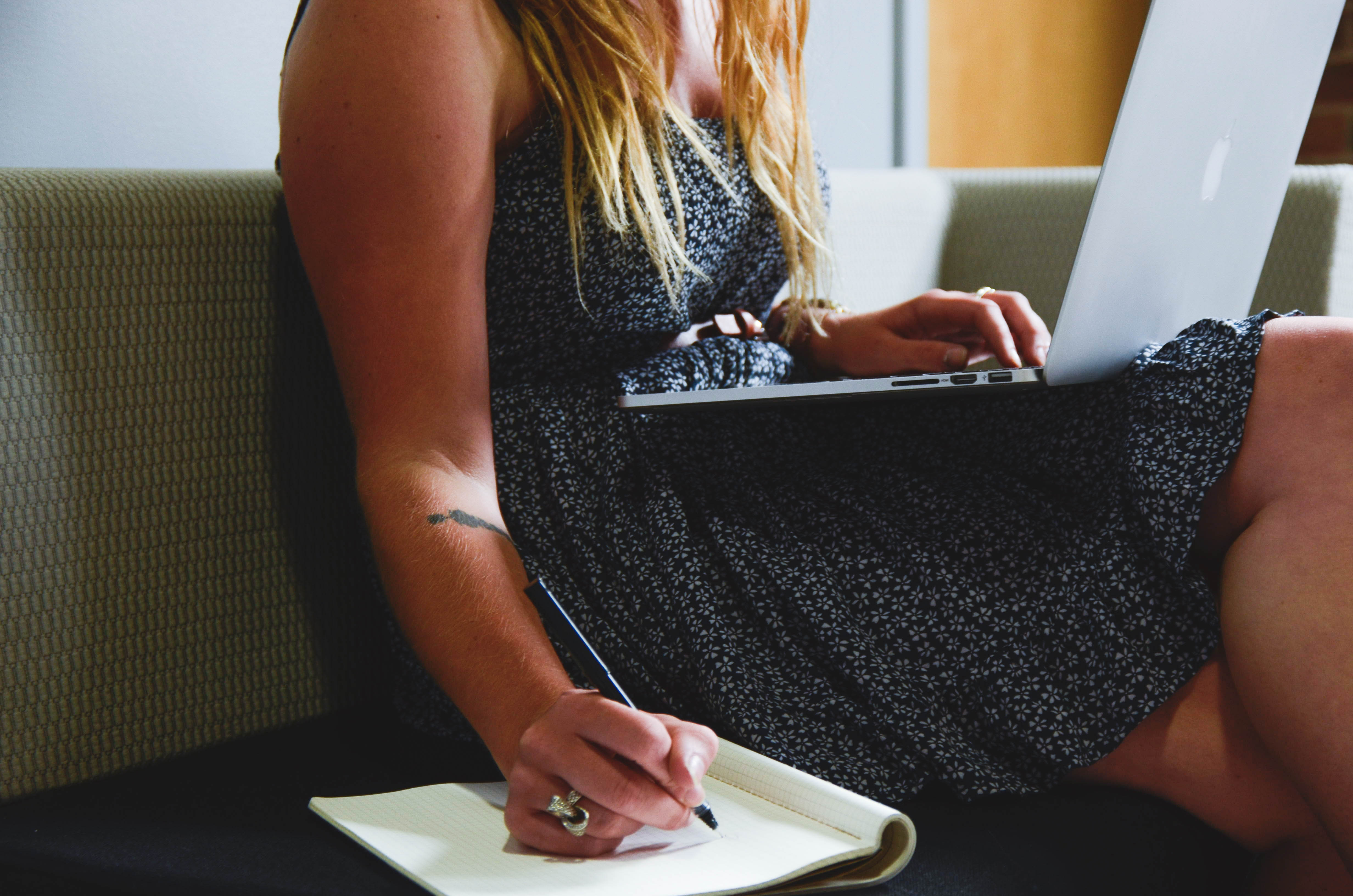 woman taking notes during skype session